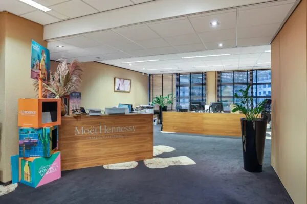 Moderne kantoorruimte aan de Oude Utrechtseweg met een houten receptiebalie van Moët Hennessy en kleurrijke display van Glenmorangie whisky.